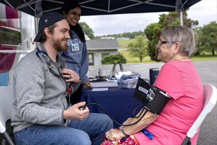 A medical professional working with an elderly person in their home