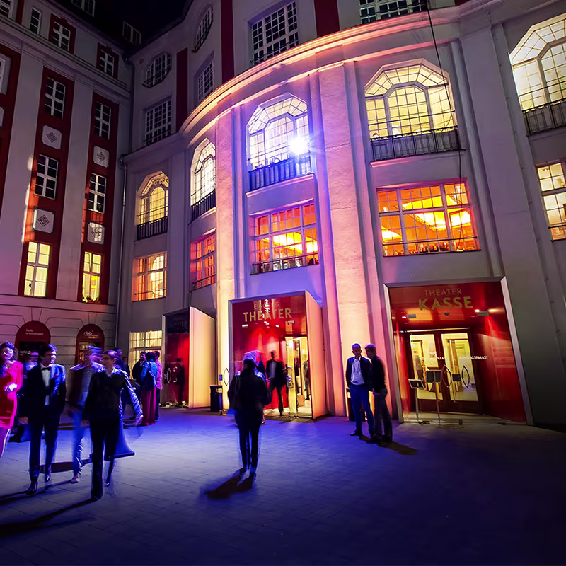 Beleuchteter Innenhof des Admiralspalast in Berlin bei Nacht mit Theaterkasse und Gästen in Abendgarderobe