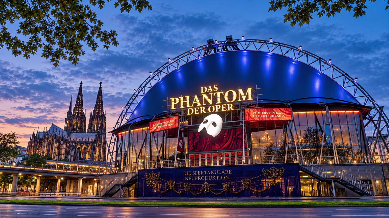Außenansicht vom Musical Dome Köln mit Logo von Das Phantom der Oper und Kölner Dom im Hintergrund