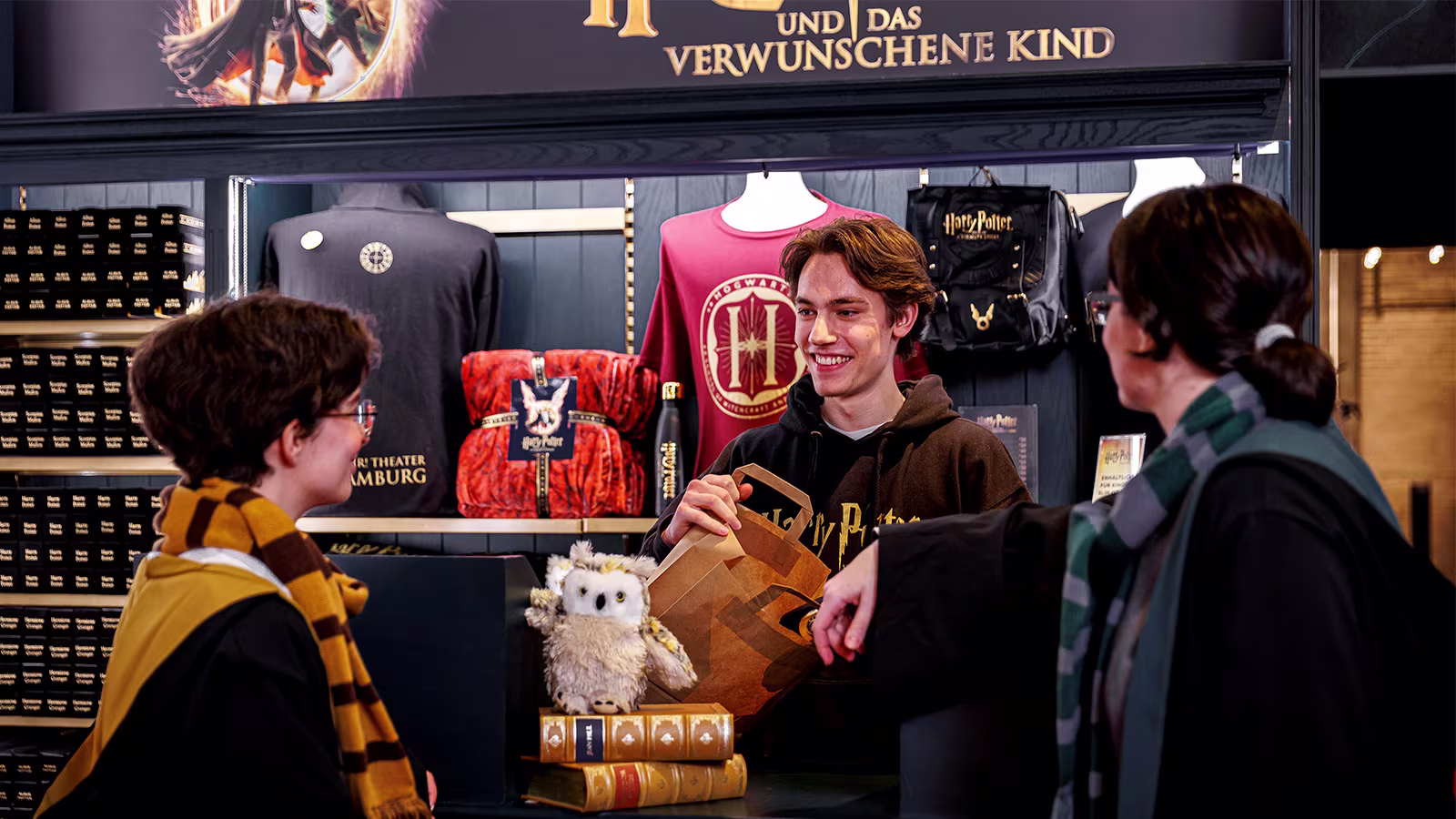 Harry Potter und das verwunschene Kind, Hamburg Merchandise Shop, Kund*innen kaufen eine Plüsch Eule