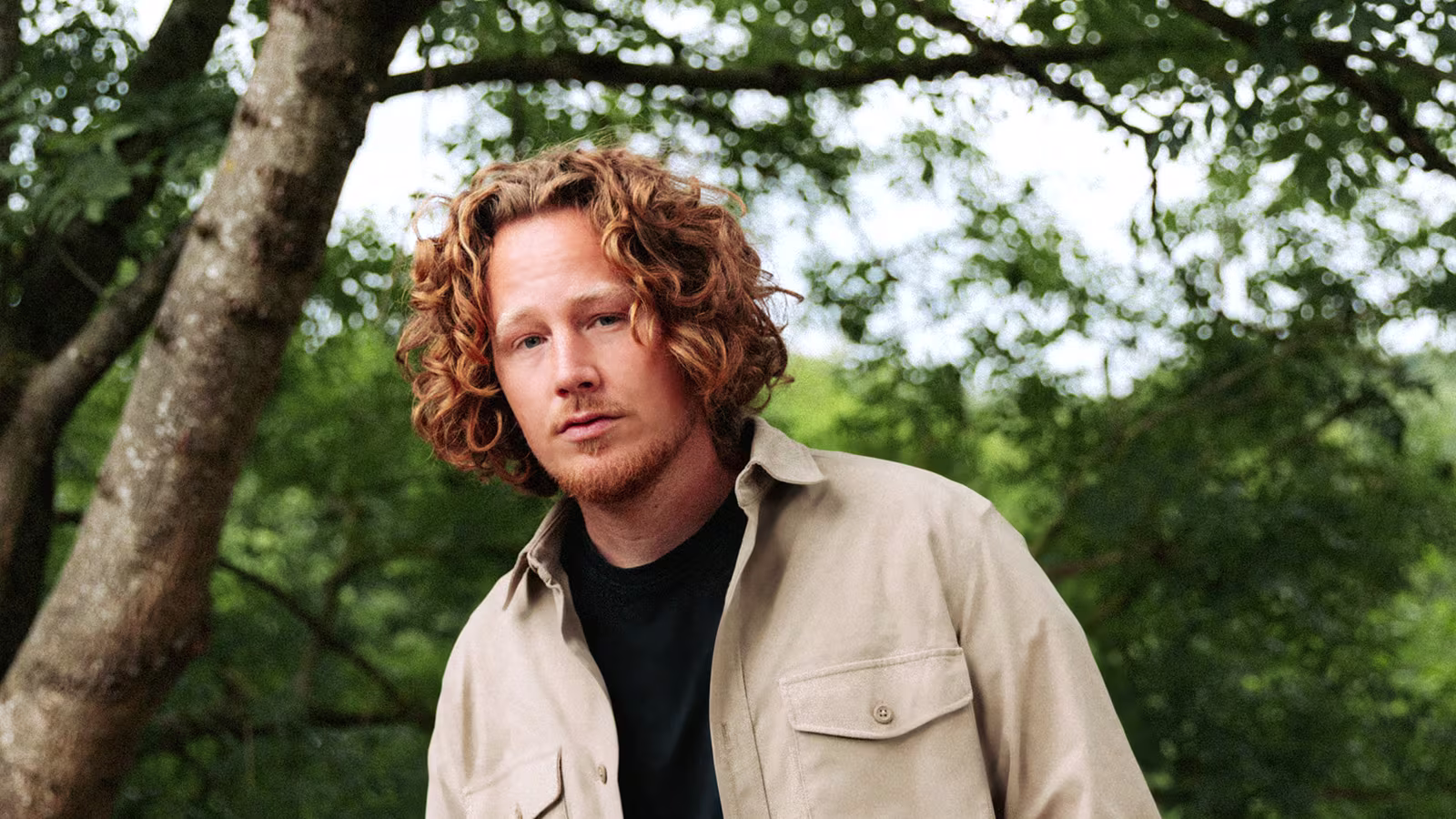 Michael Schulte steht vor grünen, großen Pflanzen