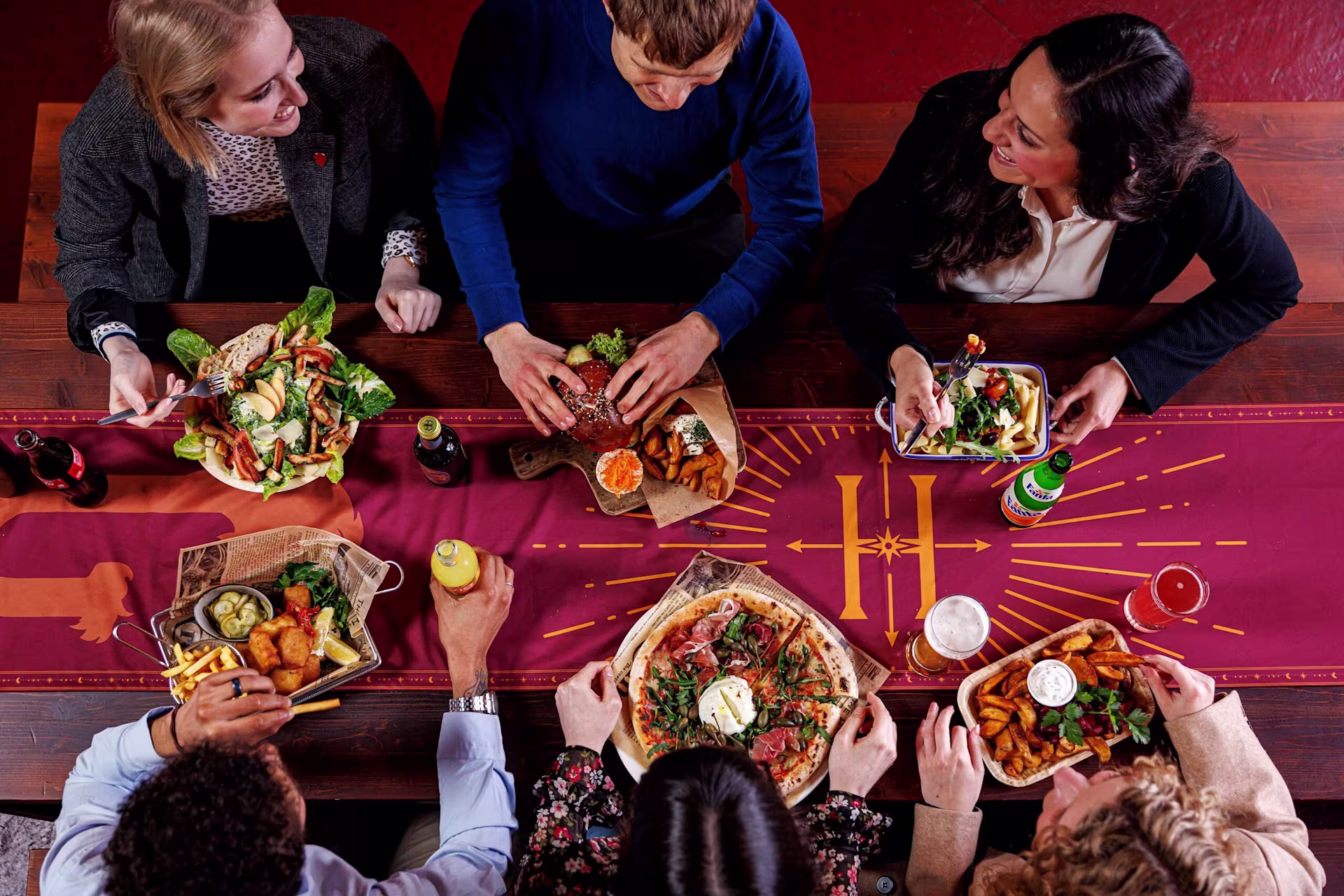 Besucher*innen sitzen beim Essen an einem Tisch 