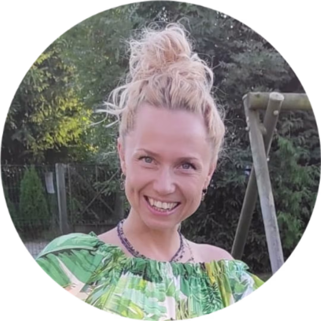 Portrait von Patrycja Flieger: Frau mit blonden Haaren im Dutt und grünem Oberteil