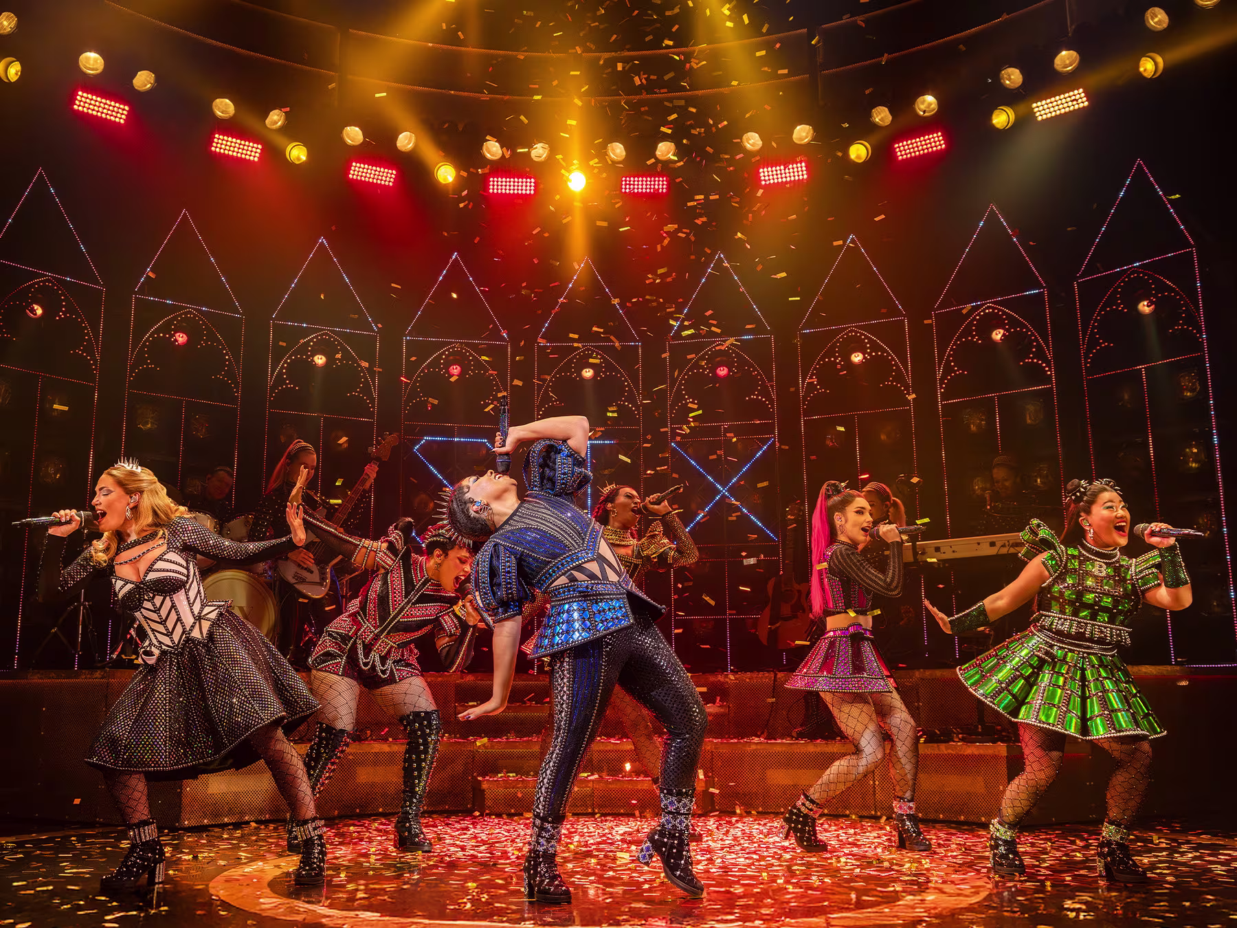 Momentaufnahme einer Szene von SIX The Musical. Die Sängerinnen haben Mikrofone in der Hand und singen.