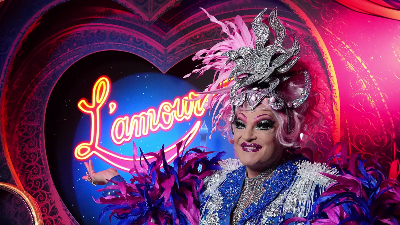 Olivia Jones sitzt vor die Bühnenbild L'amour aus Moulin Rouge! Das Musical