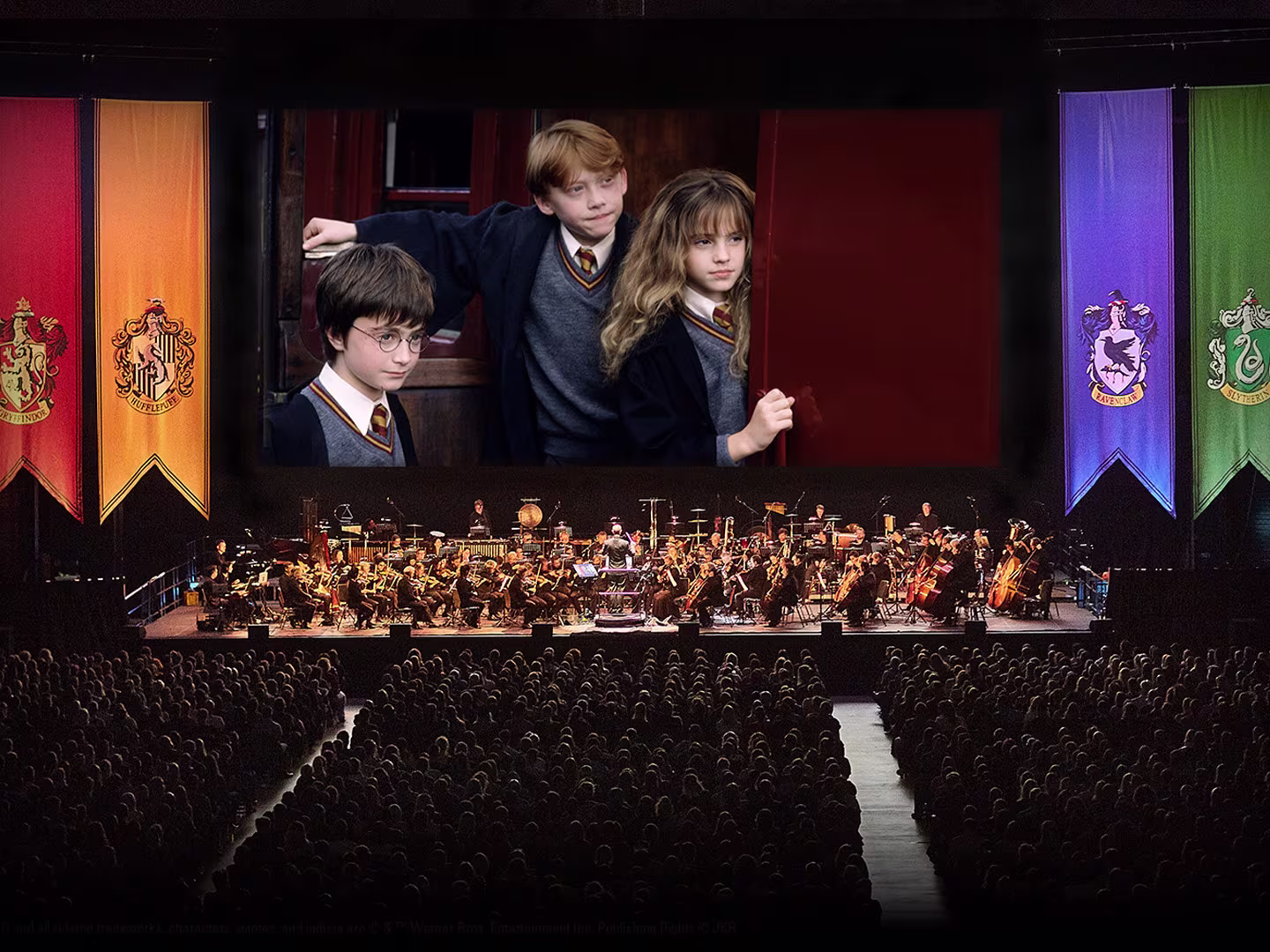 Einblicke in die Harrypottershow. Auf der Bühne das Orchester und im Hintergrund eine Leinwand.