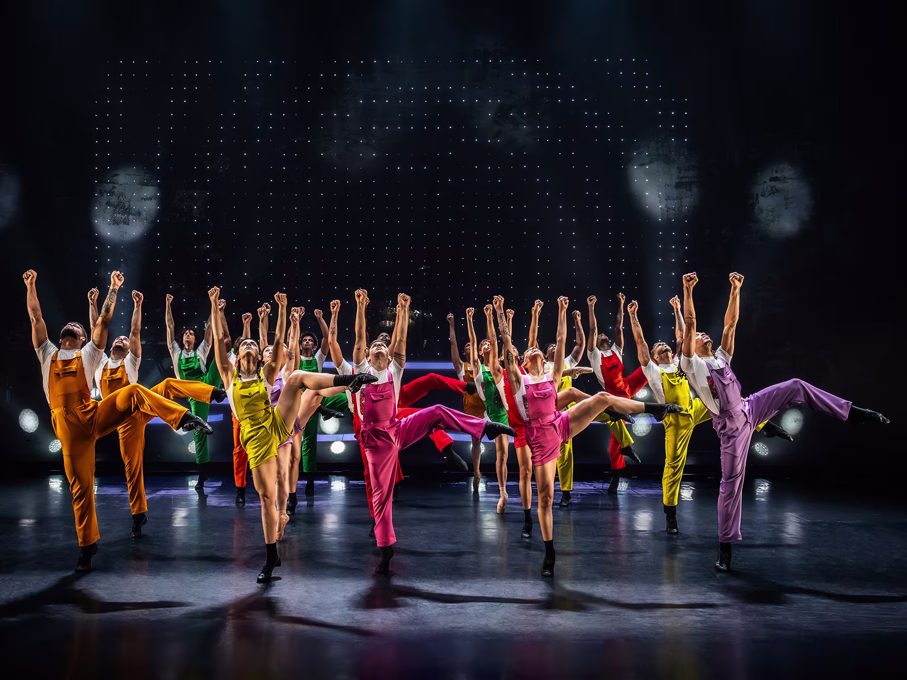 Ballet Revolución: Tänzerinnen und Tänzer sind mit bunten Outfits auf einer Bühne und tanzen synchron eine Choreografie