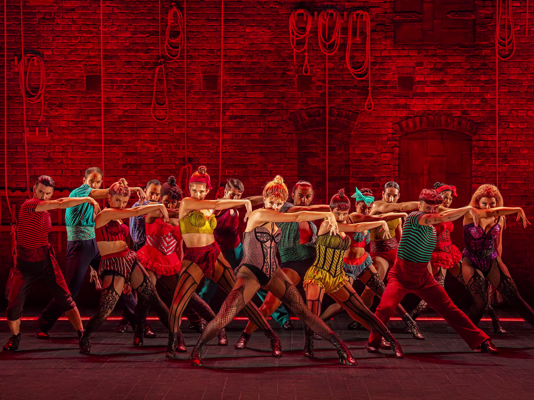 Moulin Rouge! Das Musical Showbild Ensemble mit rotem Hintergrund