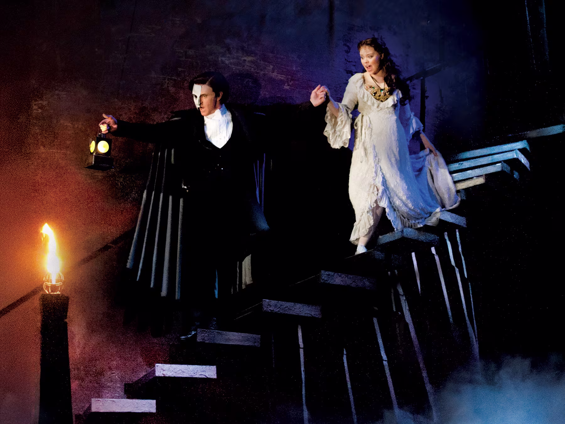 Das Phantom de Oper - Mann mit Maske und Frau gehen eine Treppe herunter