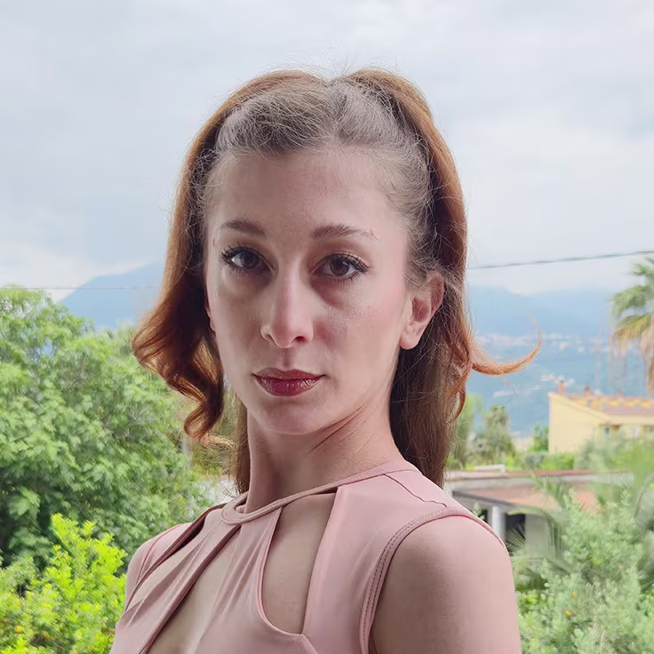 Portrait von Frau mit hellem Oberteil und langen Haaren