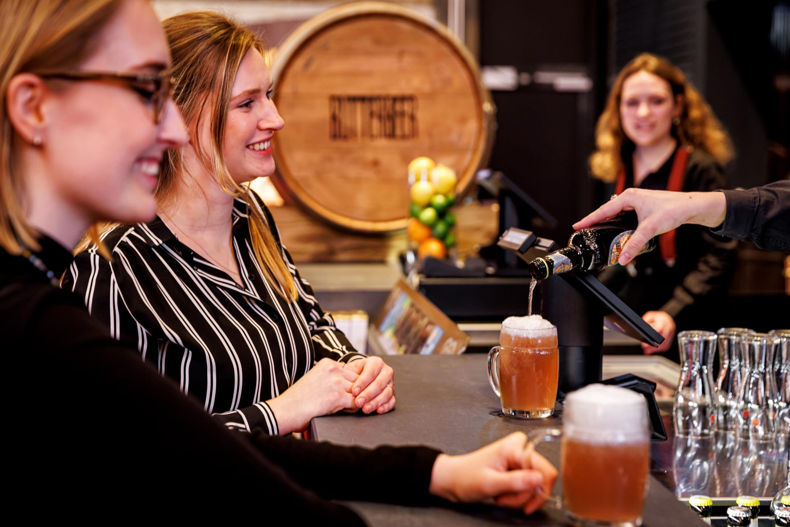 Besucher*innen mit Getränken an der Bar 