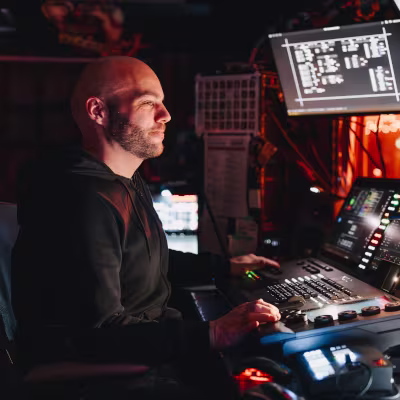 Mann mit schwarzer Kleidung und Glatze im Theater an Technik