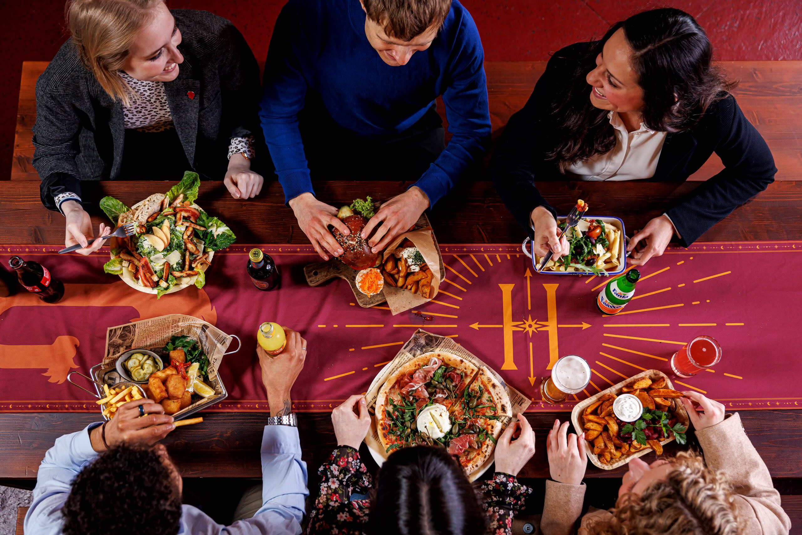 Besucher*innen beim Essen an einem Tisch 