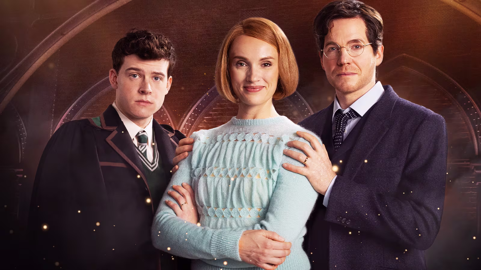 Ein Teaser-Bild zeigt drei Charaktere in einem magischen Setting. Links ein junger Mann in einer Schuluniform, in der Mitte eine Frau mit einem hellblauen Pullover und rechts ein Mann in einem eleganten Anzug mit Brille. Der Hintergrund zeigt eine magische Atmosphäre mit funkelnden Partikeln und gotischen Bögen.
