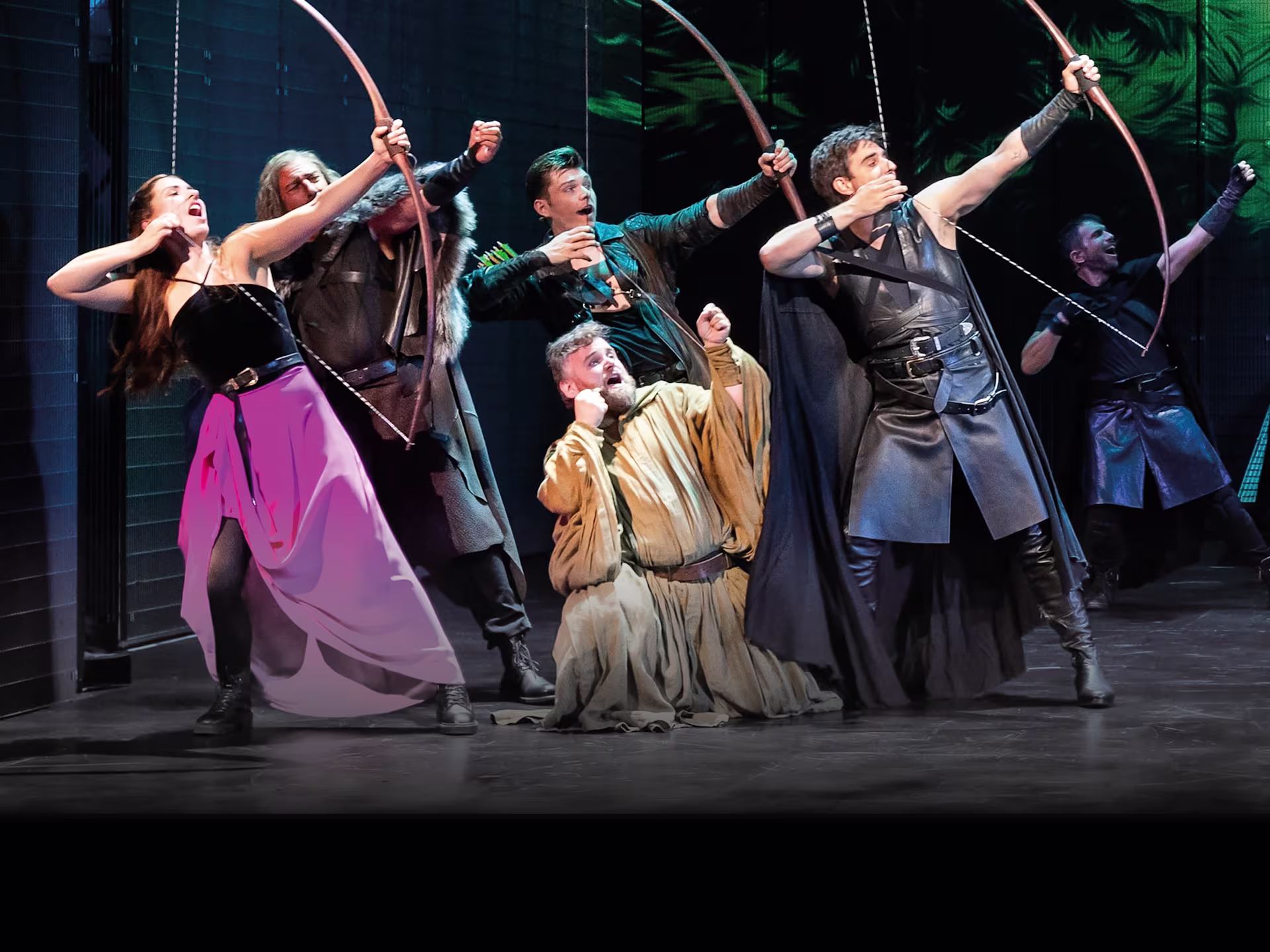 Szene aus “Robin Hood – Das Musical”: Robin Hood steht auf der Bühne mit Darstellern in mittelalterlichen Kostümen vor einer Waldkulisse.