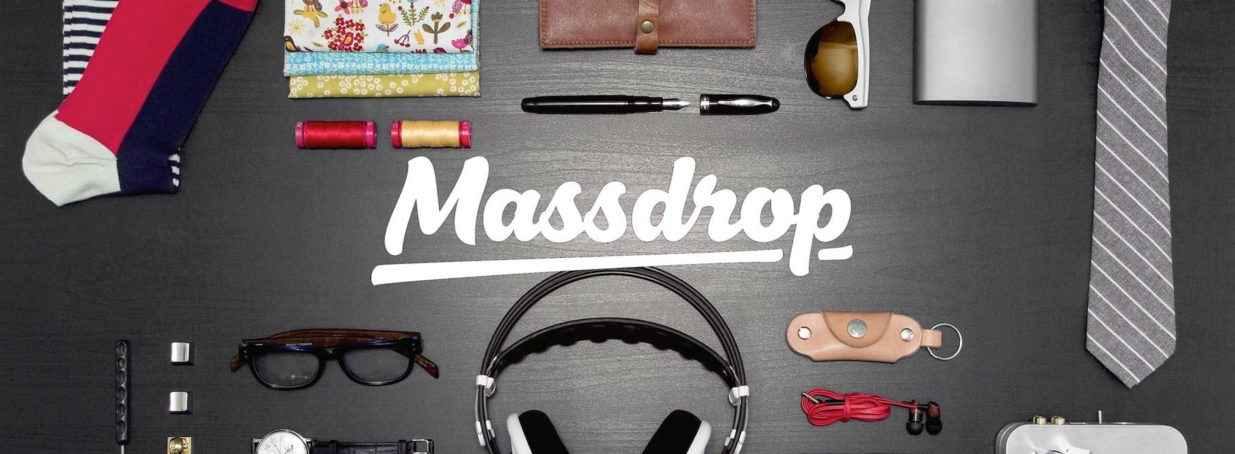 Desk with various items on it and the Massdrop logo in the center