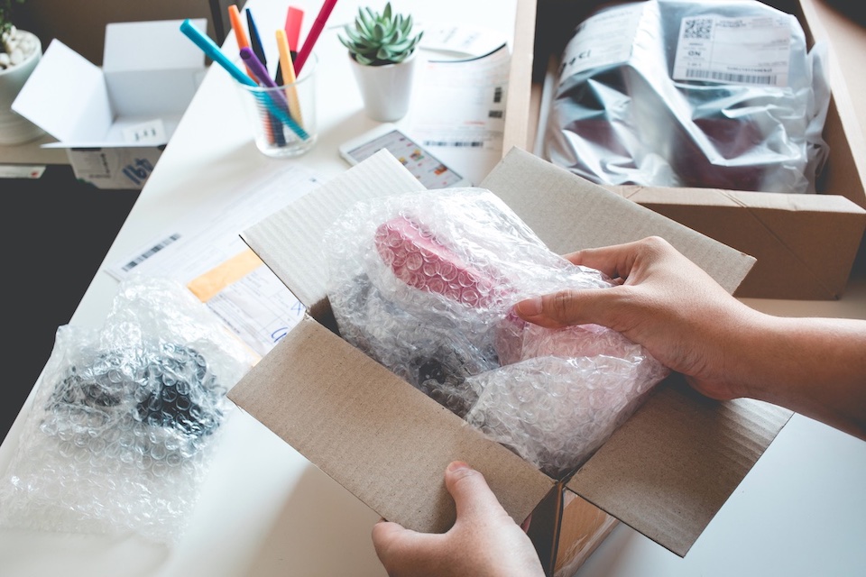 Office supplies being packed into a box for shipping