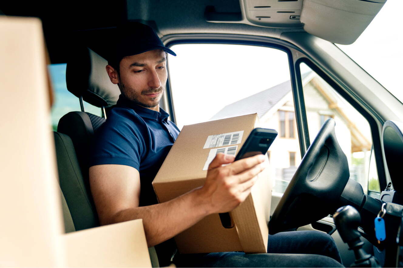 Delivery person sitting in a truck with a package