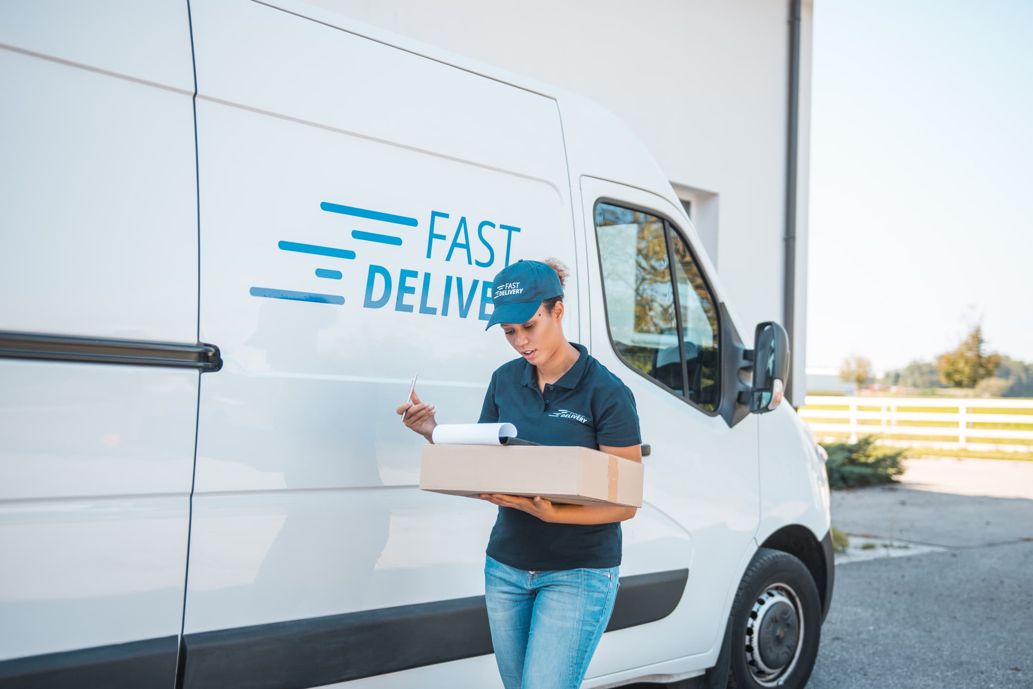 Delivery woman standing next to delivery van