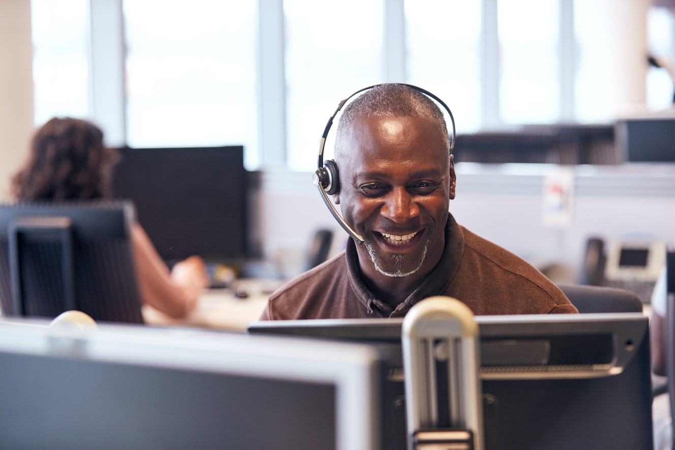 Man sitting in front of computer wearing a headset