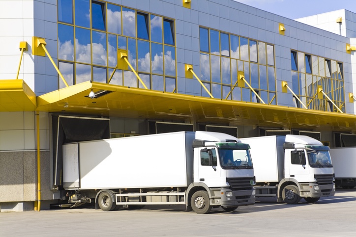 white trucks pulled up to a loading bay