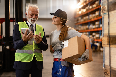 Two people looking at a tablet in a warehouse