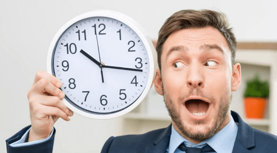 Man making a surprised face, holding a clock, and looking at it