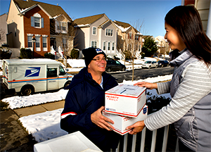 USPS mail carrier delivering packages to woman