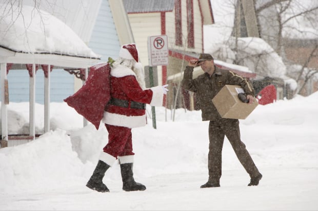 Santa Claus saying hi to a UPS worker as they pass by each other