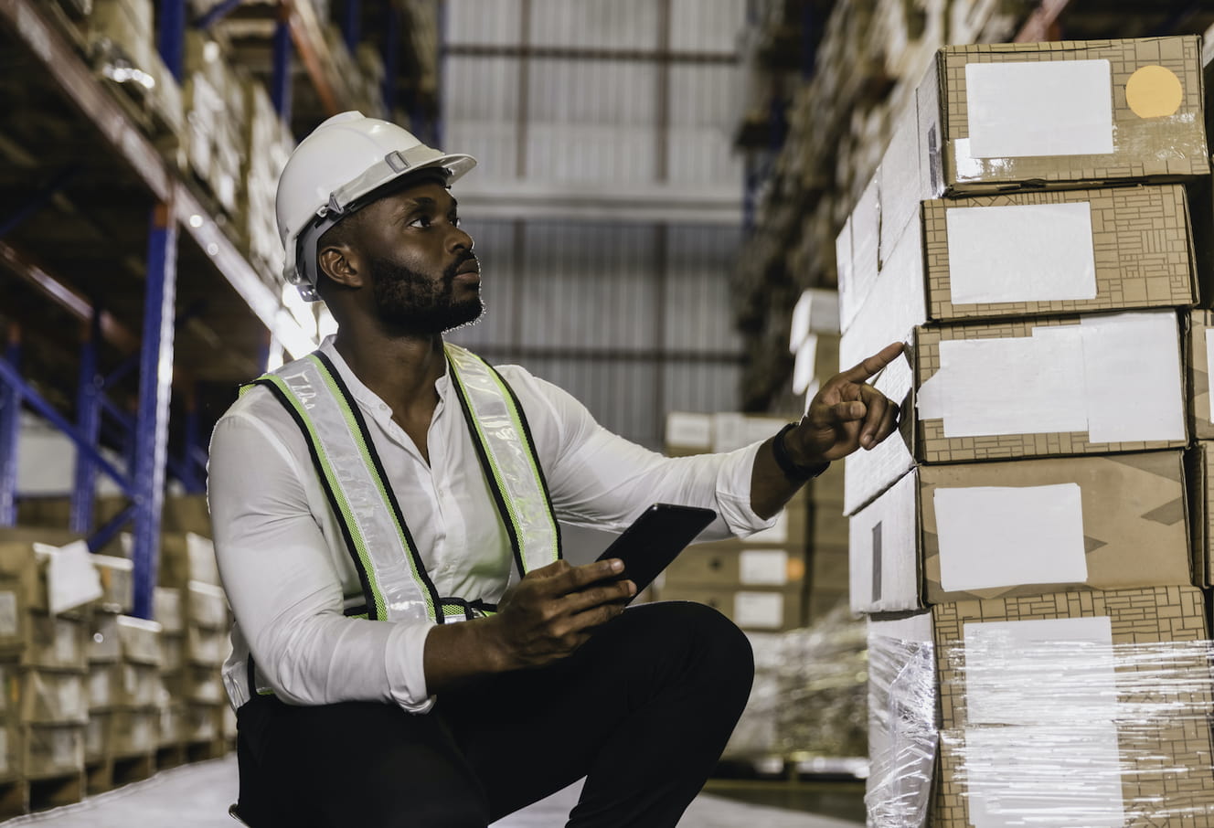 Man in warehouse counting packages