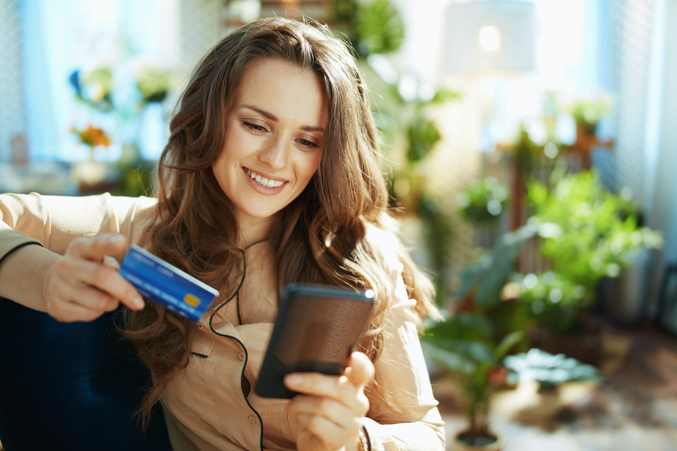 Woman putting her credit card information into her phone