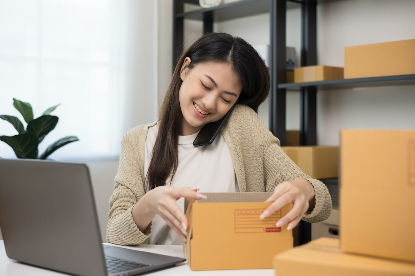 woman-packing-packages-while-on-her-phone