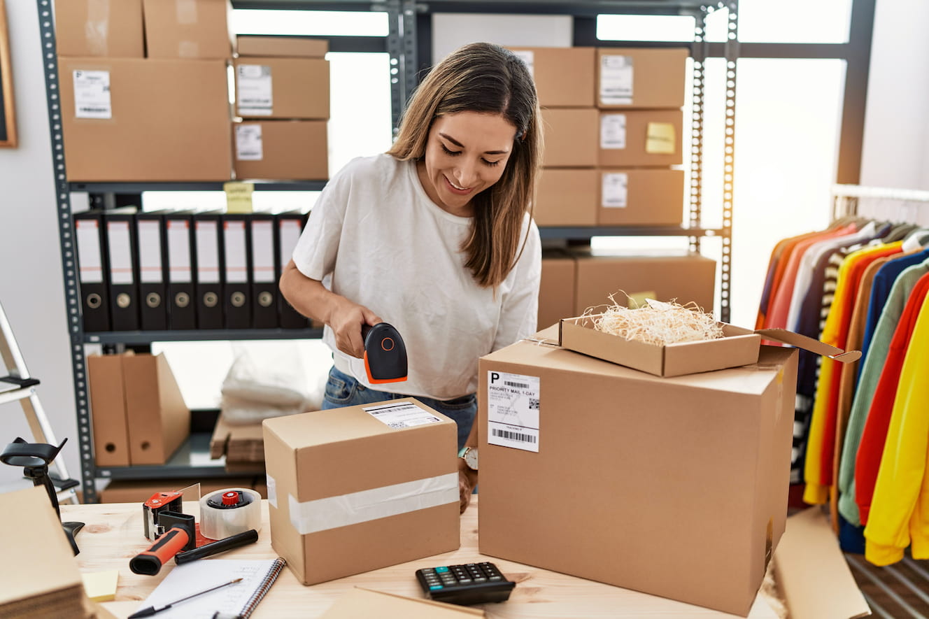 Woman in a backroom scanning packages