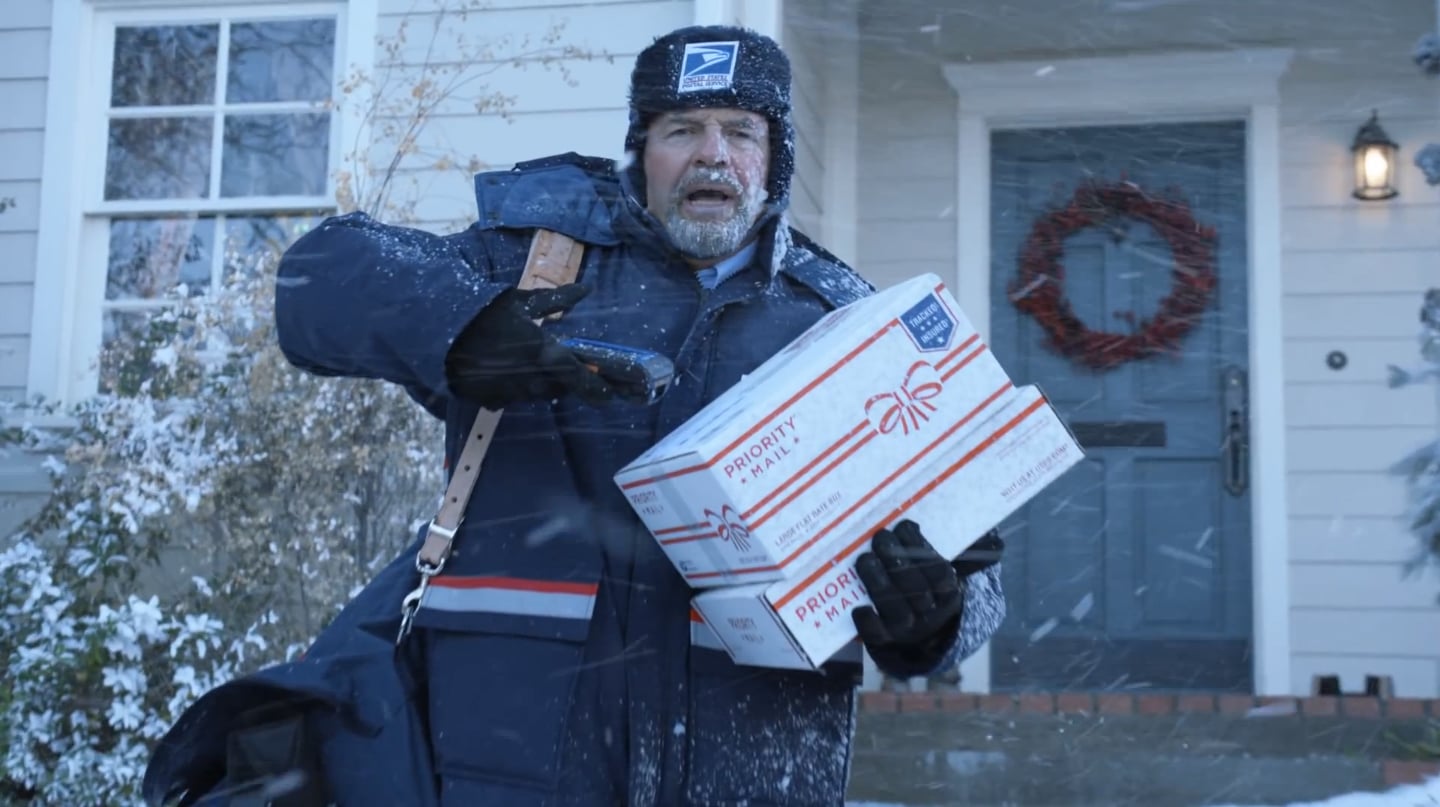USPS mail carrier delivering packages in snowy conditions