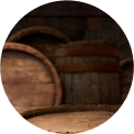 A circular image featuring several wooden barrels in a dimly lit storage area.