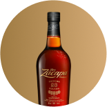 A bottle of Zacapa rum with a rich amber color, featuring elegant gold lettering on the label.