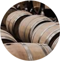 A group of wooden barrels stacked closely together, with metal hoops securing their structure.