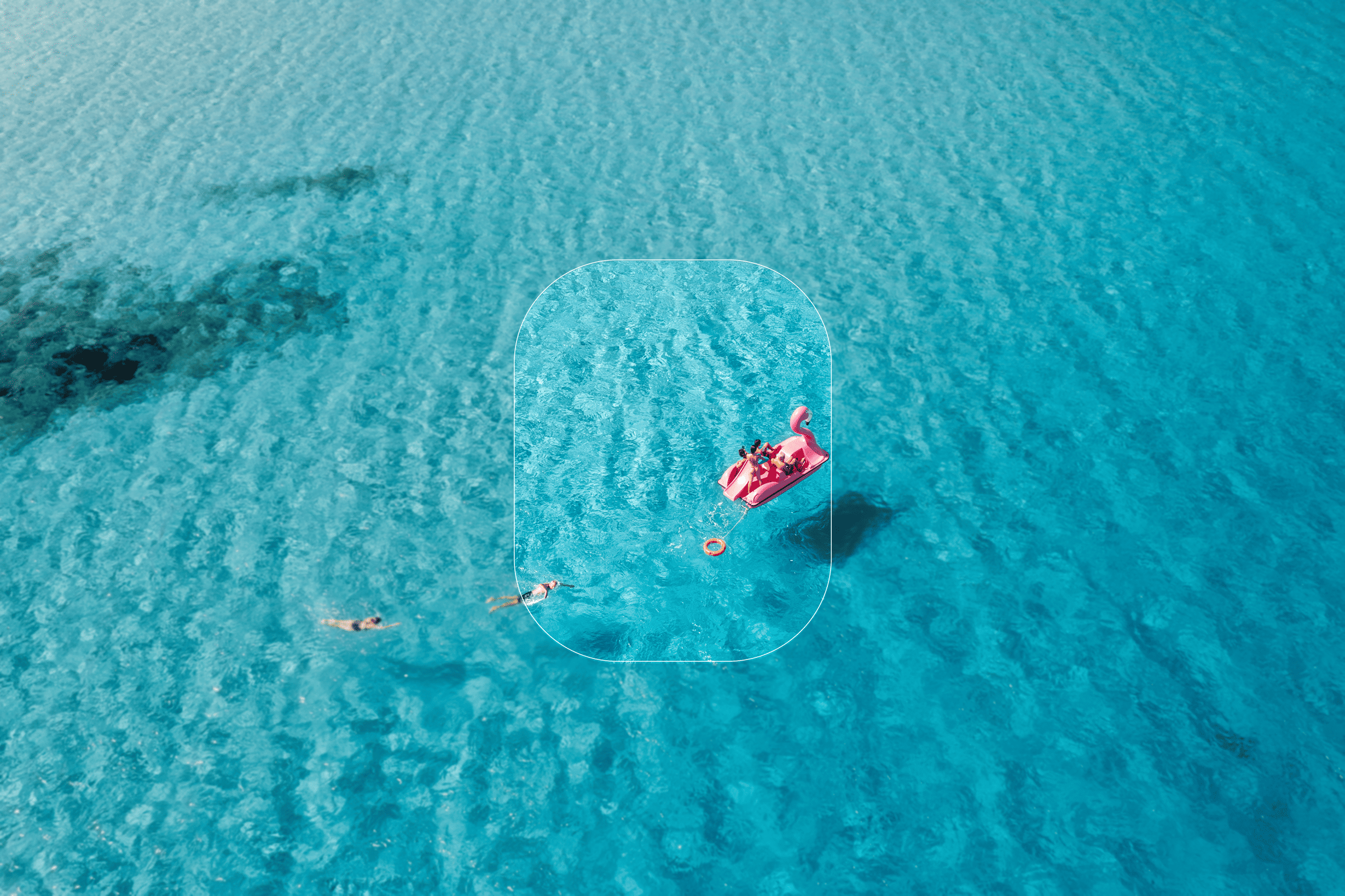 Blue water and people on a pink pedal boat