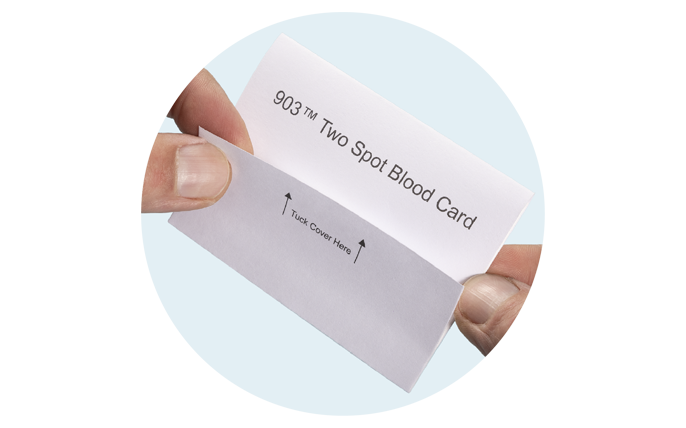 Blood sample collection card being folded.