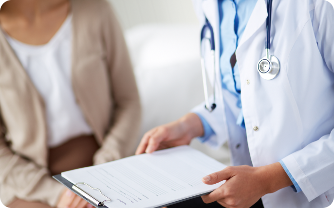Doctor holding a report standing beside a patient.