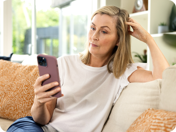 Woman sitting on sofa using her smartphone