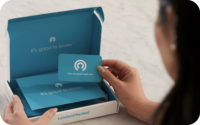 Woman opening a LetsGetChecked testing kit.
