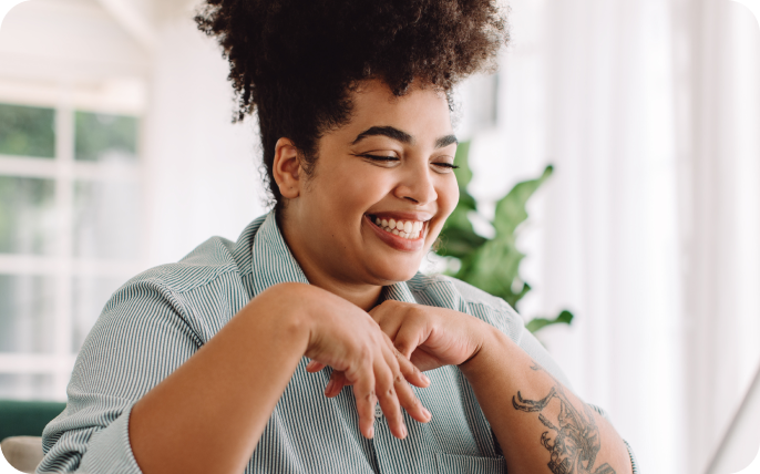 Smiling woman using her laptop in an indoor setting.