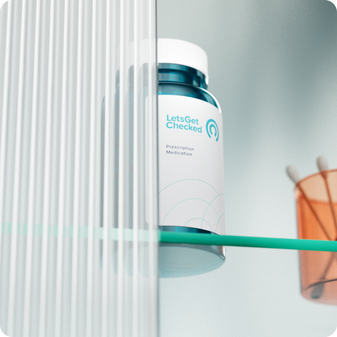 LetsGetChecked branded pill bottle on a glass surface. LetsGetChecked branded pill bottle on a glass surface.