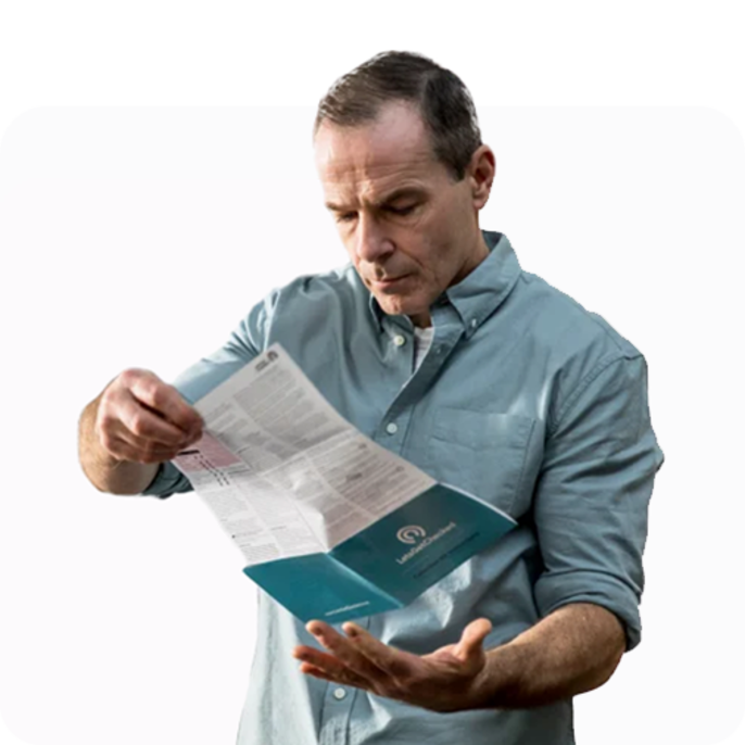 Older man reading the instructional pamphlet provided by the LetsGetChecked testing kit.