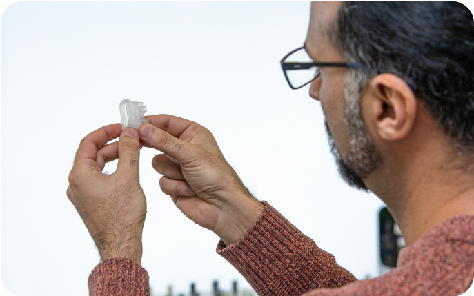 Taufeeq Elahi Diju holding the ImPress device.