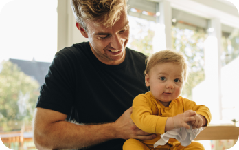 Father holding his baby in the kitchen.