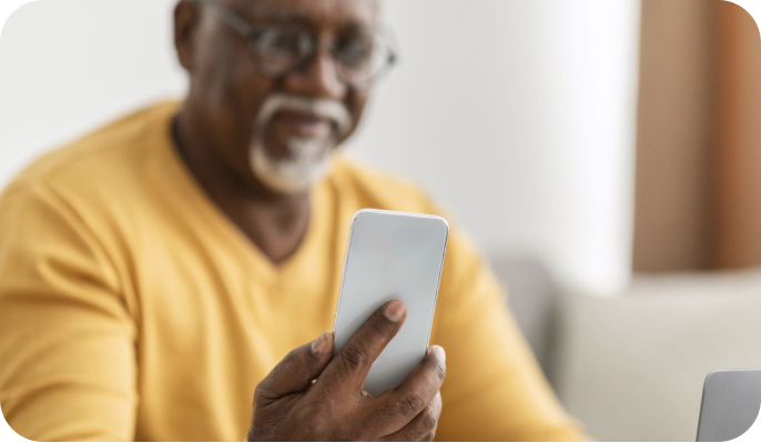 Older man using his smartphone from the comfort of his home. Older man using his smartphone from the comfort of his home.