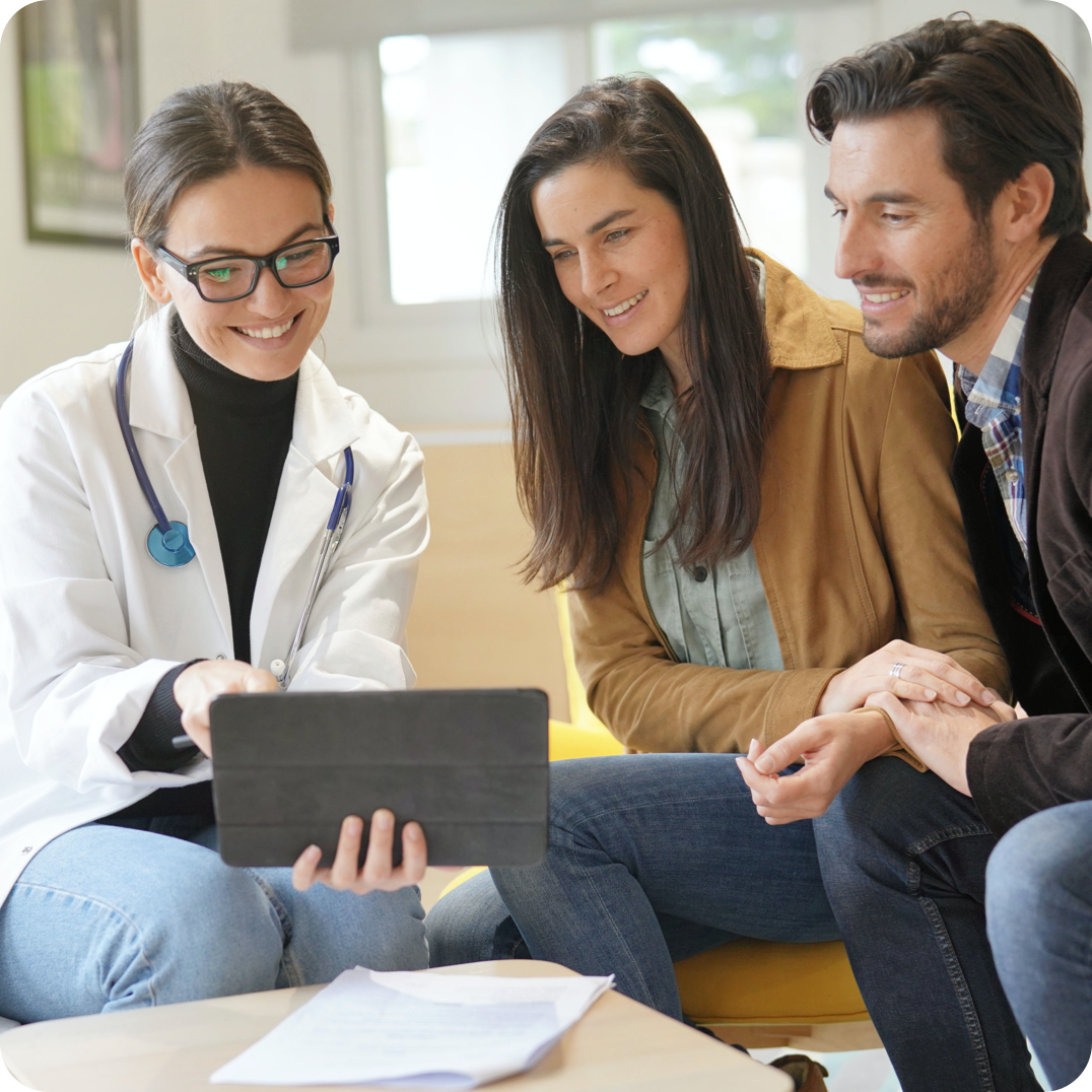 Couple looking at results on tablet with clinical team member