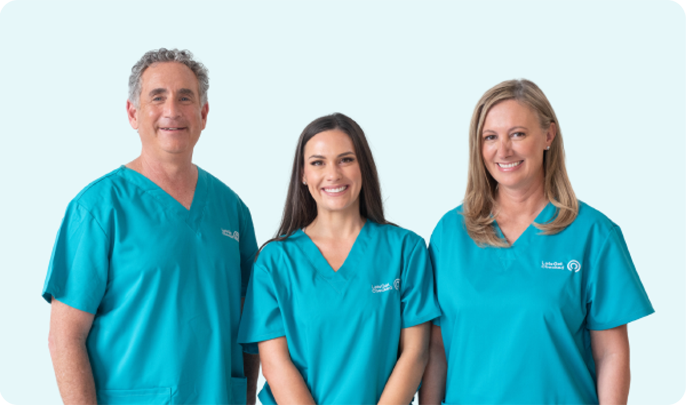 Three content, LetsGetChecked, healthcare professionals in teal scrubs standing side by side.